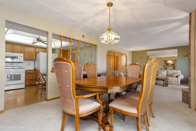 a dining room with furniture a chandelier and window