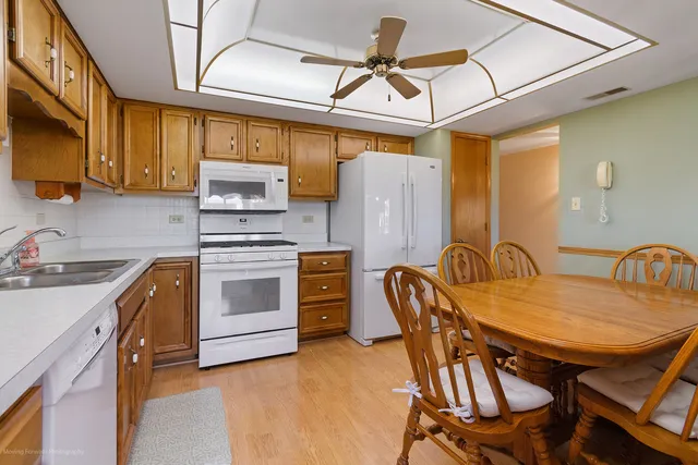 a kitchen with stainless steel appliances granite countertop a stove a sink dishwasher and cabinets with wooden floor