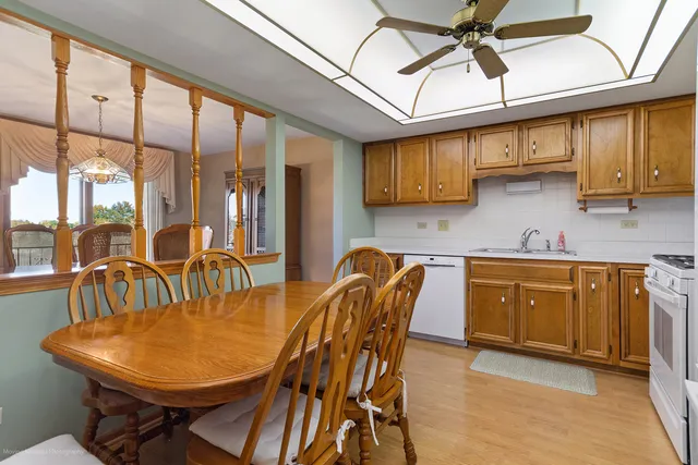 a kitchen with stainless steel appliances granite countertop a sink a table and chairs