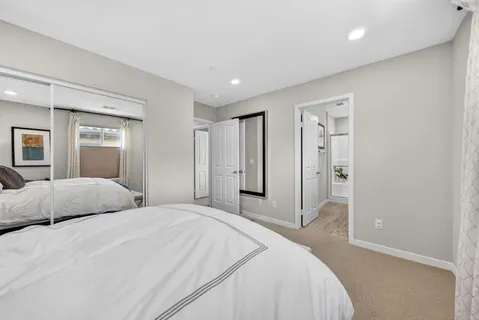 a bedroom with a large bed and a chandelier