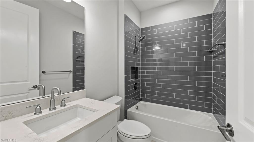 4641 Centaurus Circle Naples, FL 34120 - Photo 14 of 31 a bathroom with a bathtub shower sink vanity and toilet