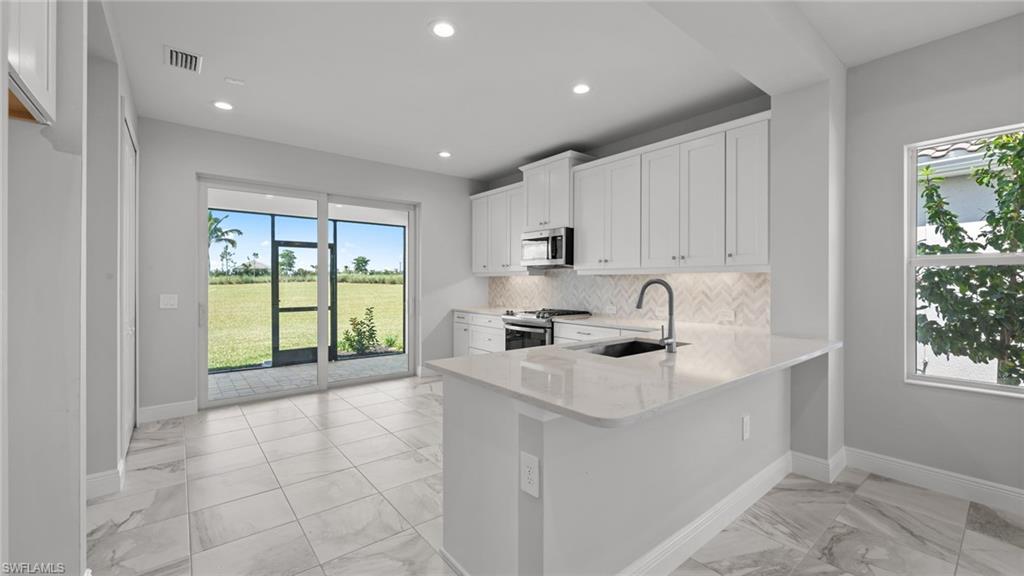 4641 Centaurus Circle Naples, FL 34120 - Photo 18 of 31 a kitchen with a sink a window and cabinets