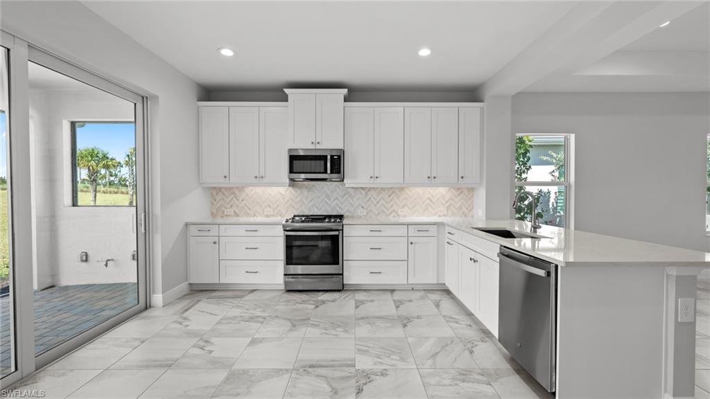 4641 Centaurus Circle Naples, FL 34120 - Photo 20 of 31 a kitchen with granite countertop a stove a sink and a refrigerator
