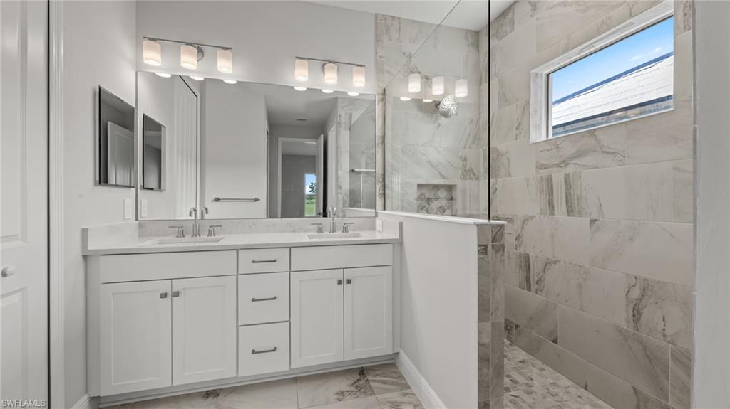 4641 Centaurus Circle Naples, FL 34120 - Photo 26 of 31 a bathroom with a double vanity sink and a mirror