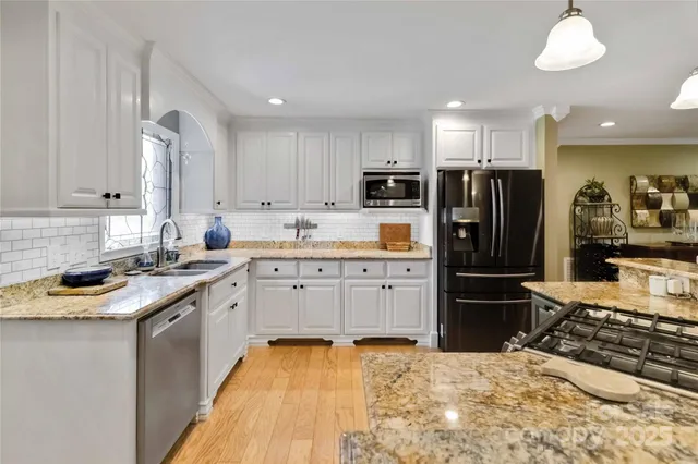 a kitchen with kitchen island granite countertop a sink stove and refrigerator