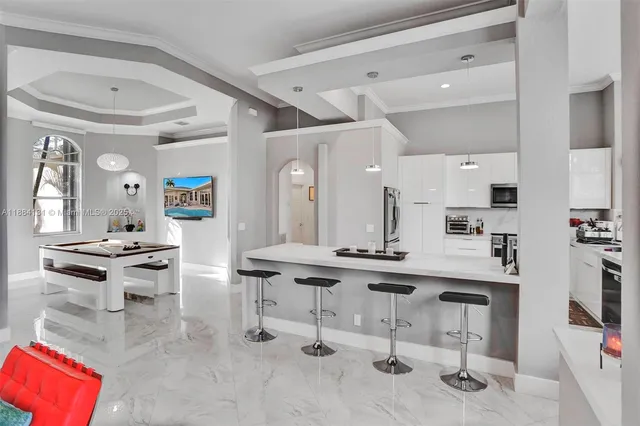 a room with stainless steel appliances kitchen island granite countertop furniture and a view of kitchen