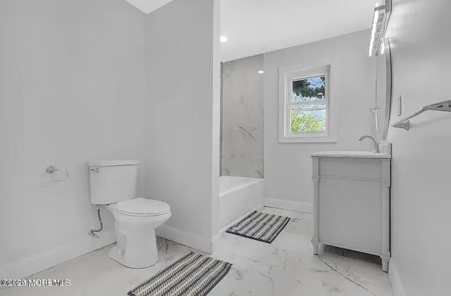a bathroom with a sink toilet and a window