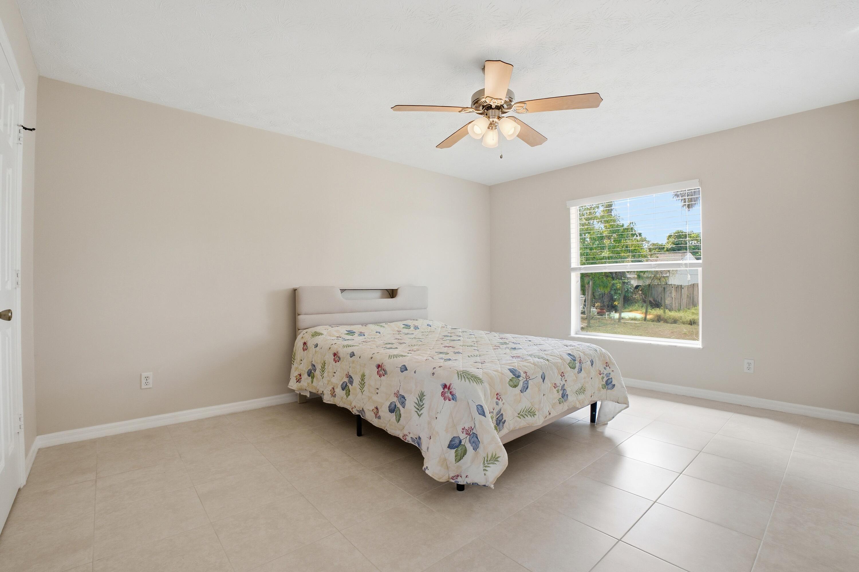5809 Killarney Avenue Fort Pierce, FL 34951 - Photo 17 of 29 a bedroom with a bed and window