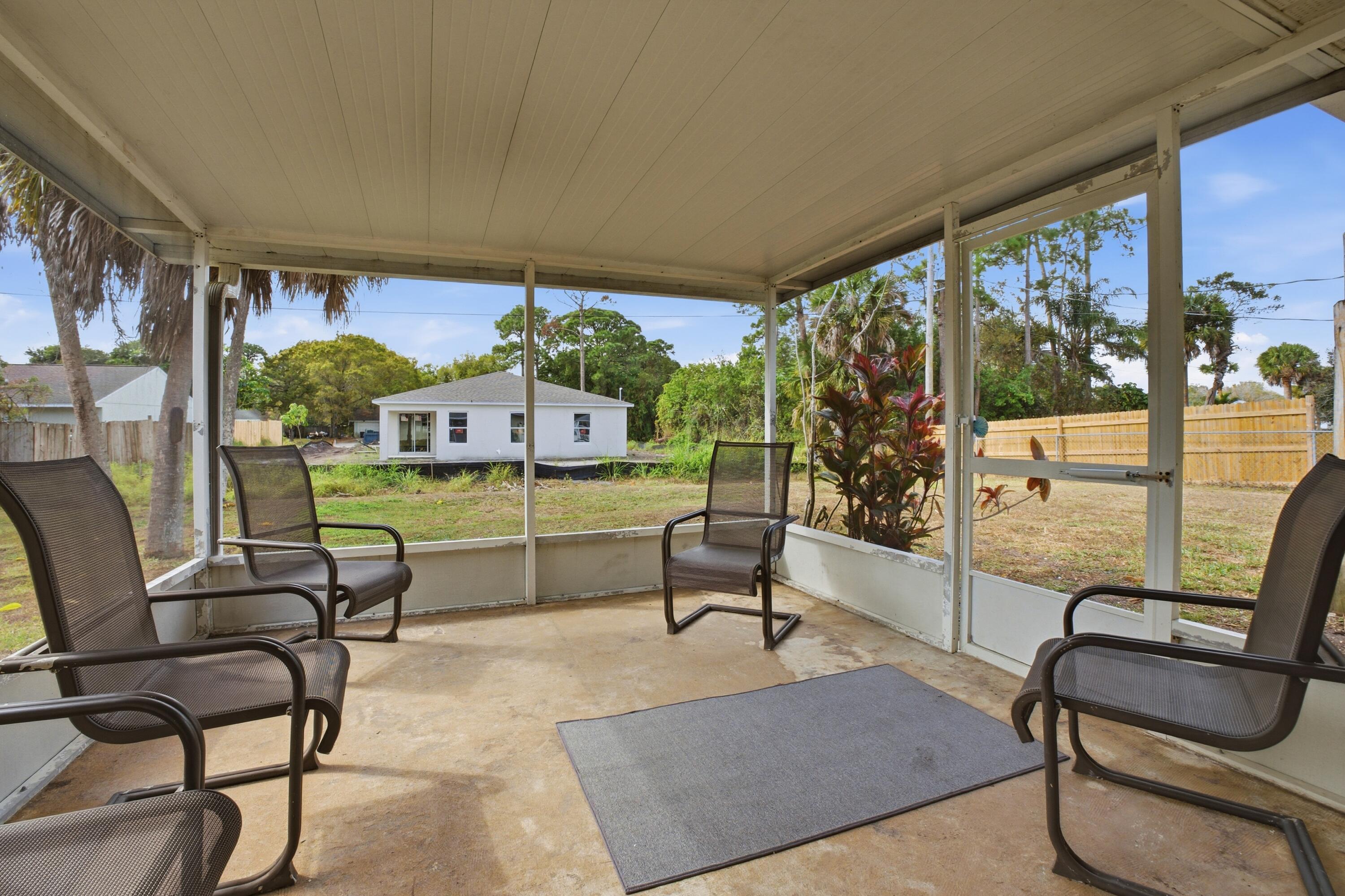5809 Killarney Avenue Fort Pierce, FL 34951 - Photo 22 of 29 a living room with furniture and a floor to ceiling window