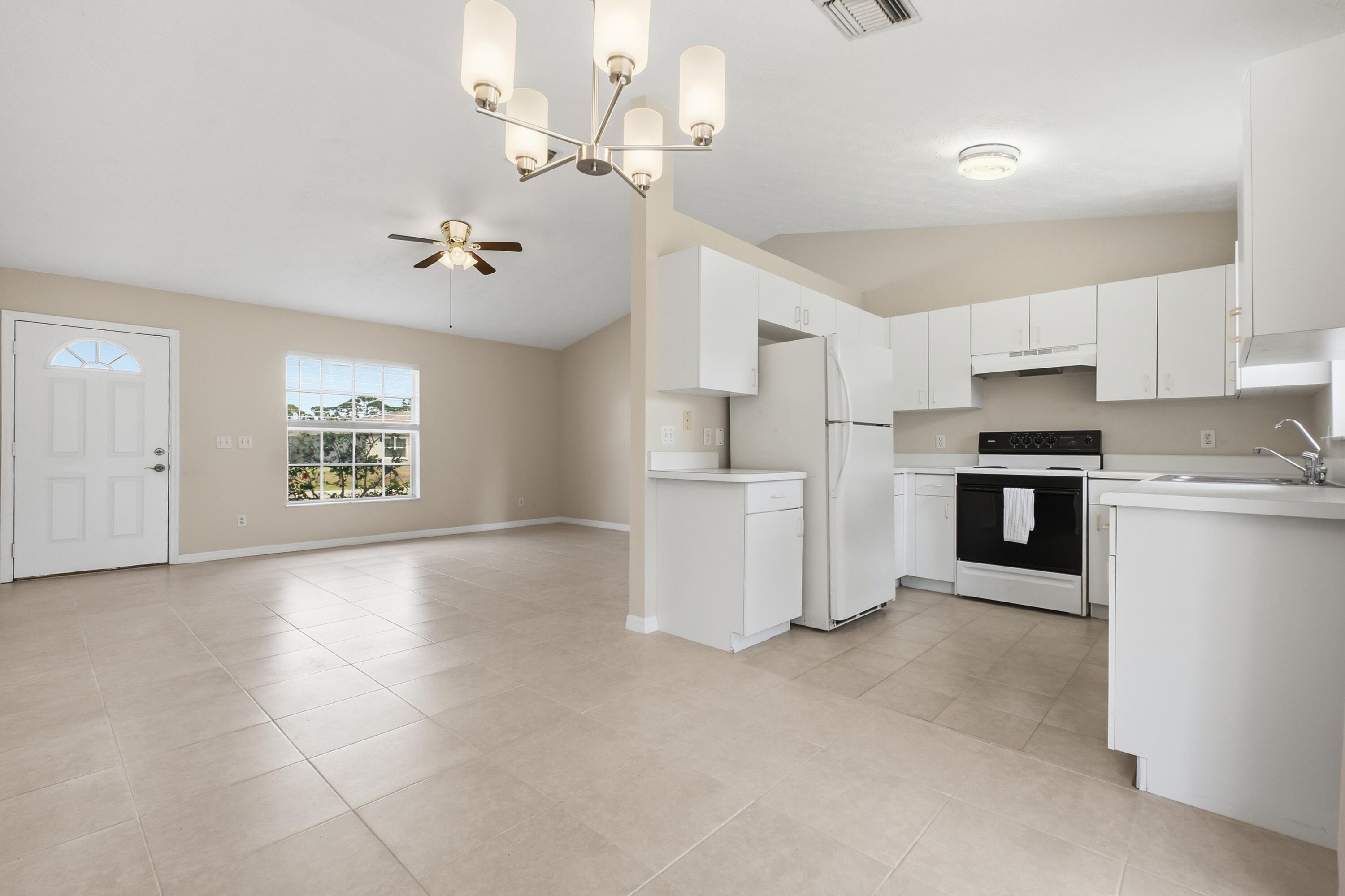 5809 Killarney Avenue Fort Pierce, FL 34951 - Photo 5 of 29 a view of a kitchen with a sink and dishwasher a refrigerator with white cabinets