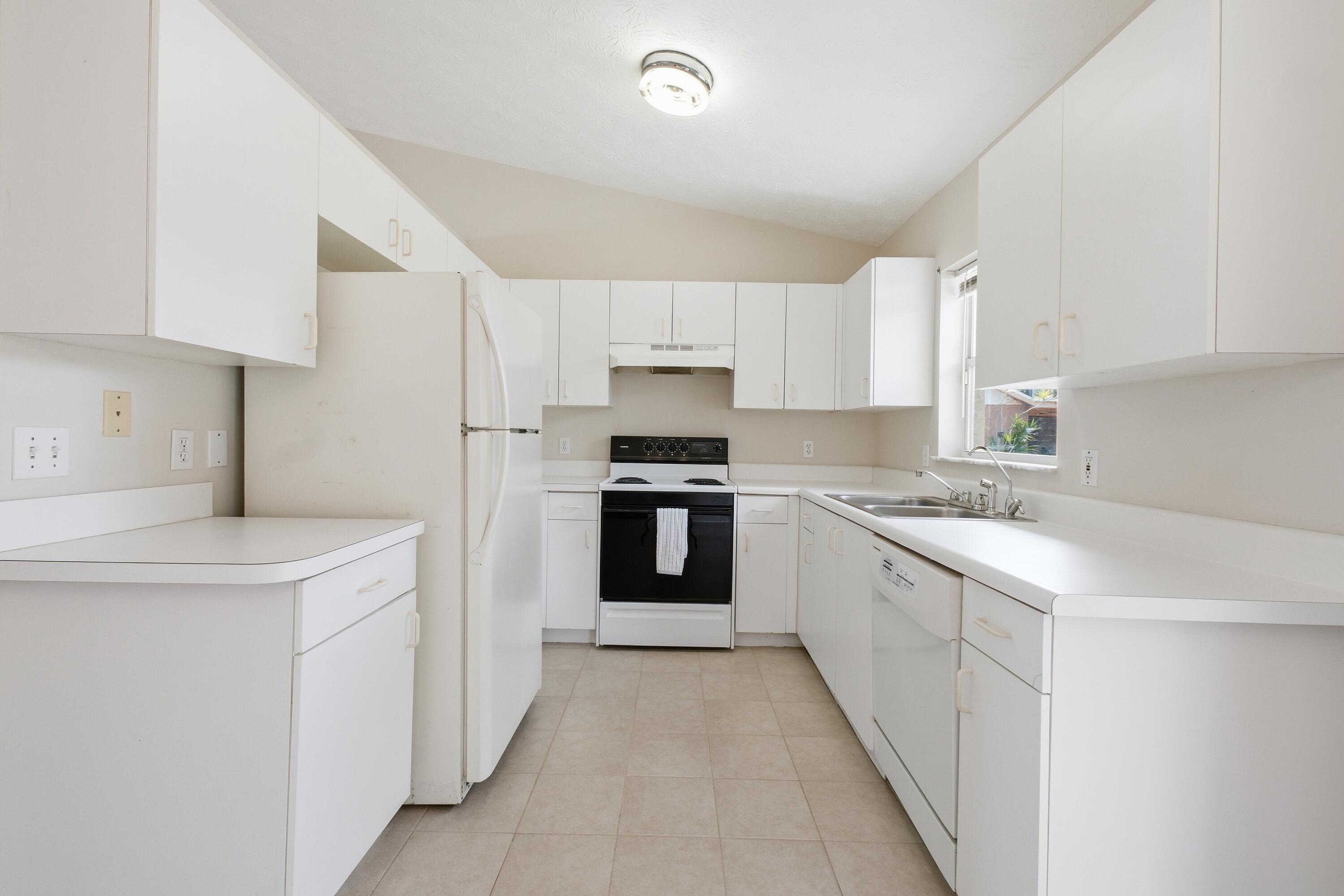 5809 Killarney Avenue Fort Pierce, FL 34951 - Photo 8 of 29 a kitchen with granite countertop white cabinets and stainless steel appliances