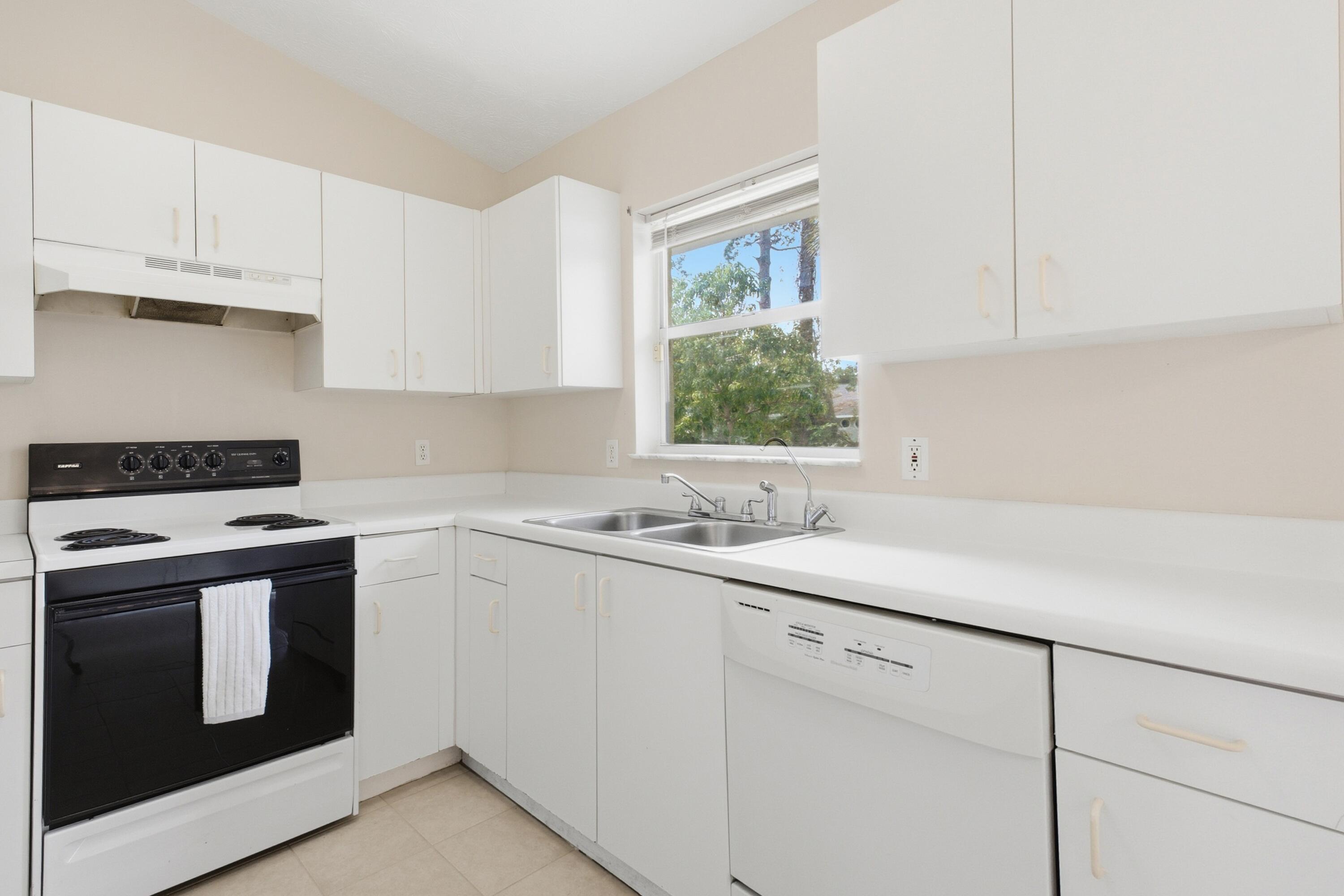 5809 Killarney Avenue Fort Pierce, FL 34951 - Photo 10 of 29 a kitchen with appliances cabinets and a window