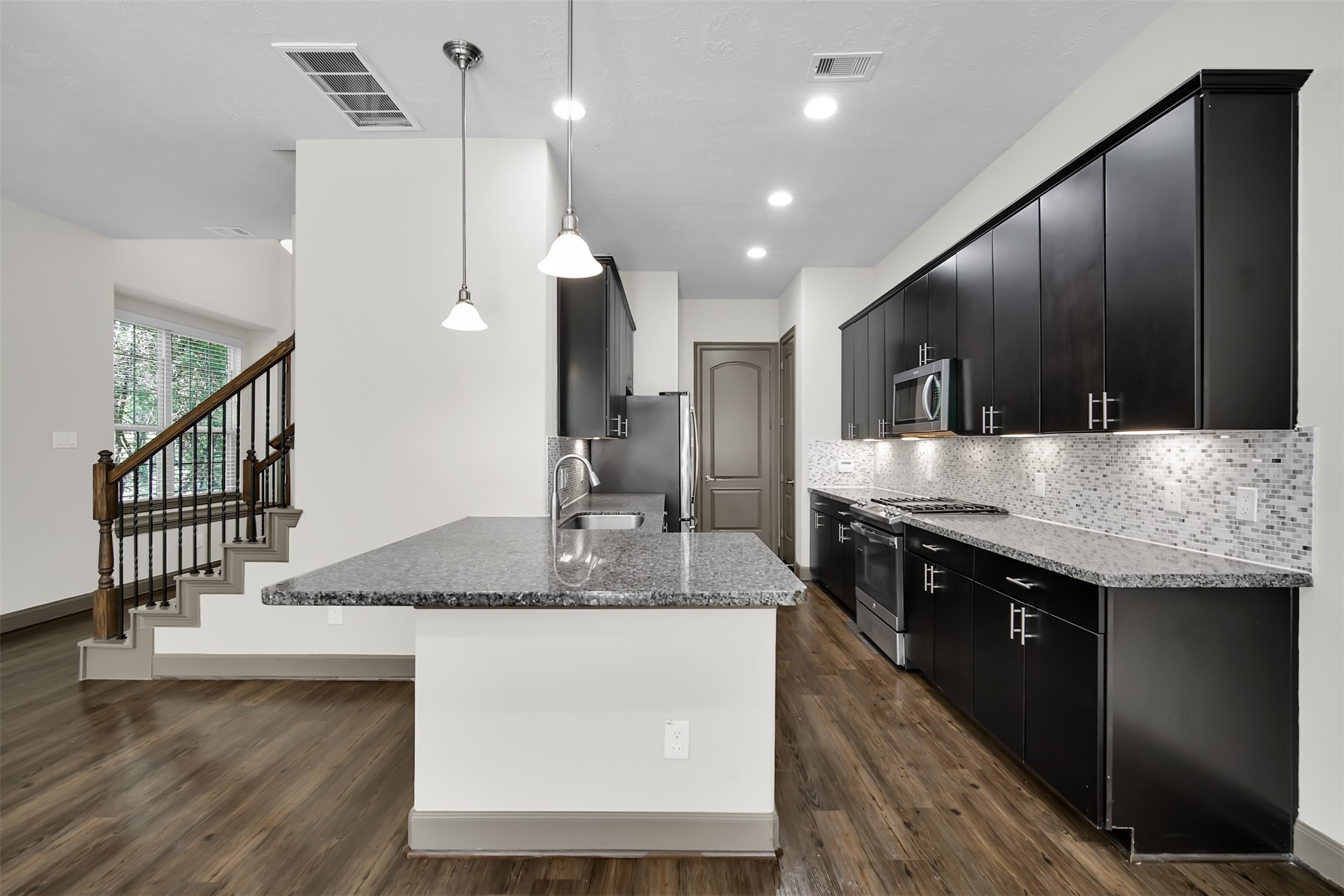 111 Aventura Place Spring, TX 77389 - Photo 13 of 42 a kitchen with stainless steel appliances granite countertop a sink a stove and a wooden floors