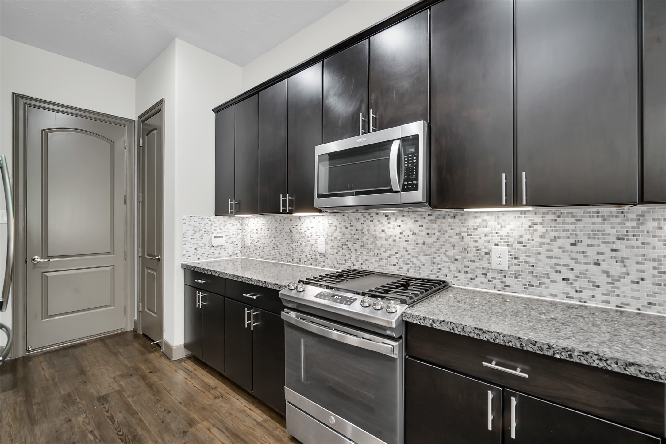 111 Aventura Place Spring, TX 77389 - Photo 15 of 42 a kitchen with granite countertop cabinets stainless steel appliances and wooden floor