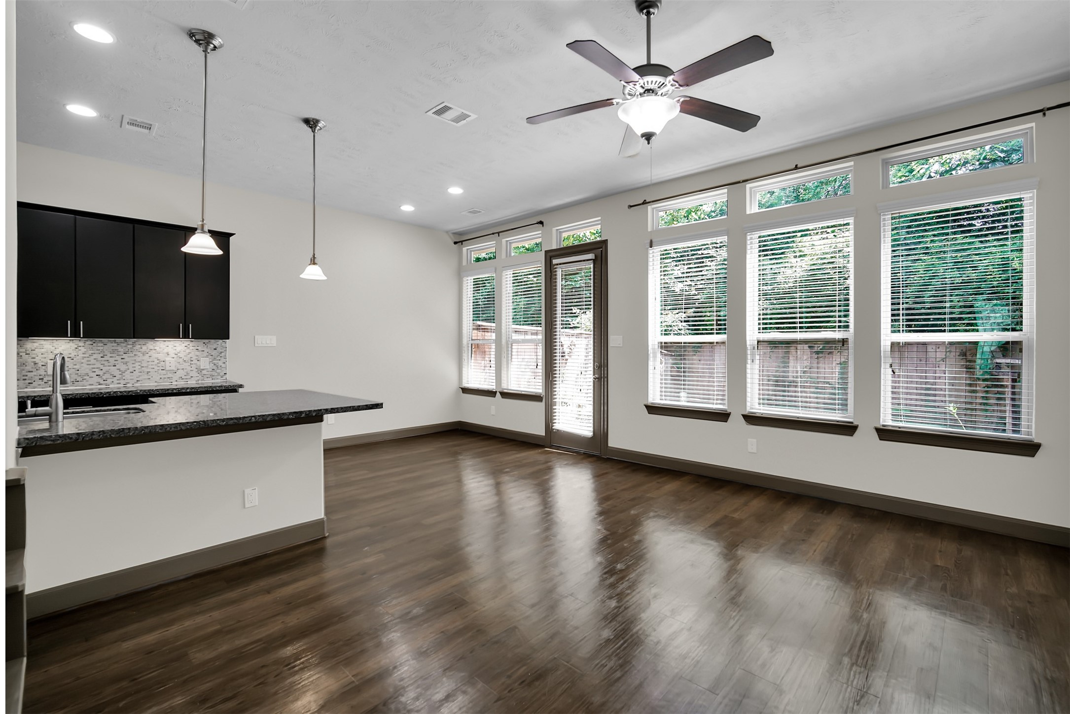 111 Aventura Place Spring, TX 77389 - Photo 7 of 42 a large kitchen with stainless steel appliances granite countertop a stove a sink a large window with wooden floor and a flat screen tv