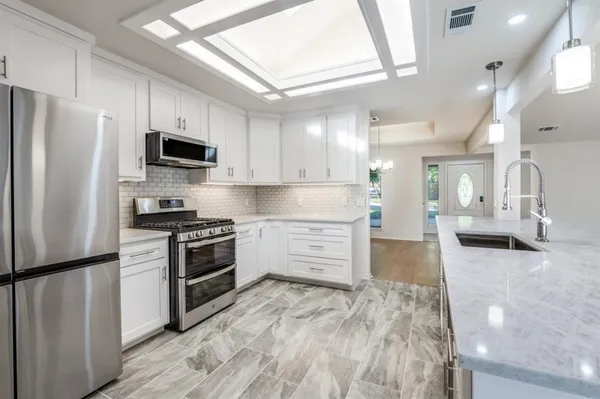 a kitchen with stainless steel appliances a refrigerator stove and microwave