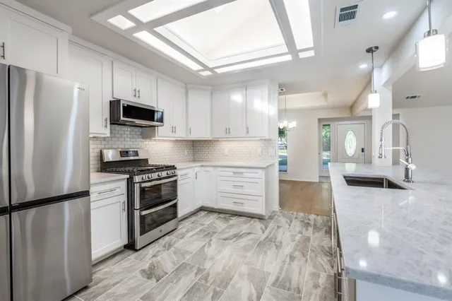a kitchen with stainless steel appliances a refrigerator stove and microwave