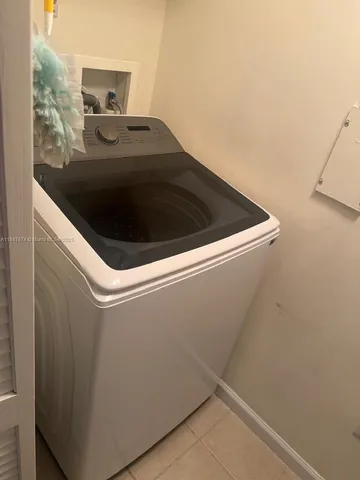 a living room with furniture and view of kitchen