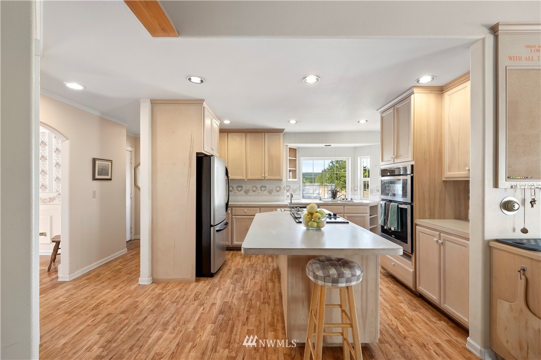 165 Conradi Road Winlock, WA 98596 - Photo 12 of 40 a large kitchen with granite countertop a large counter top stainless steel appliances and wooden floor