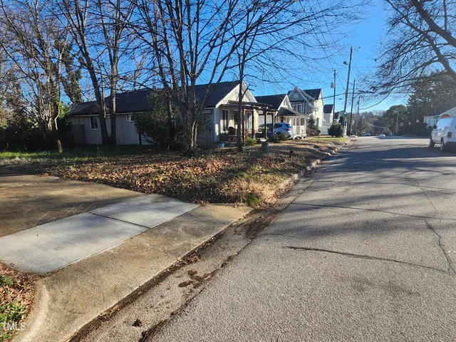 a view of a house with a yard covered in the forest