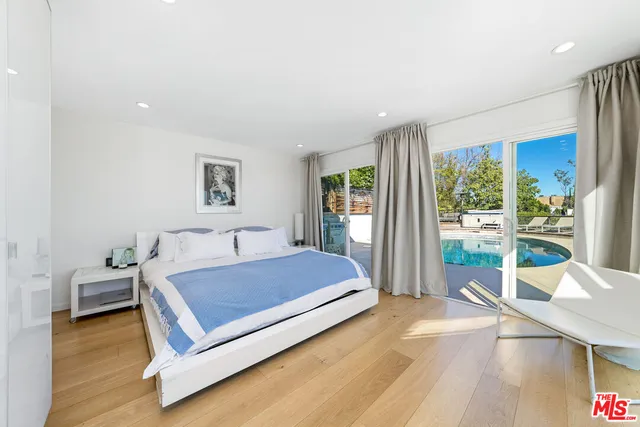 a living room with a bed furniture and large windows