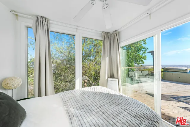 a bedroom with a bed and a large window