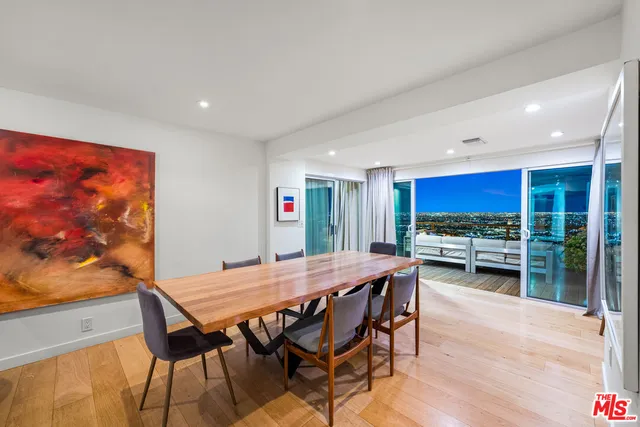 a living room with stainless steel appliances furniture and a kitchen view