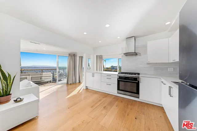 a large kitchen with stainless steel appliances granite countertop a stove and a sink