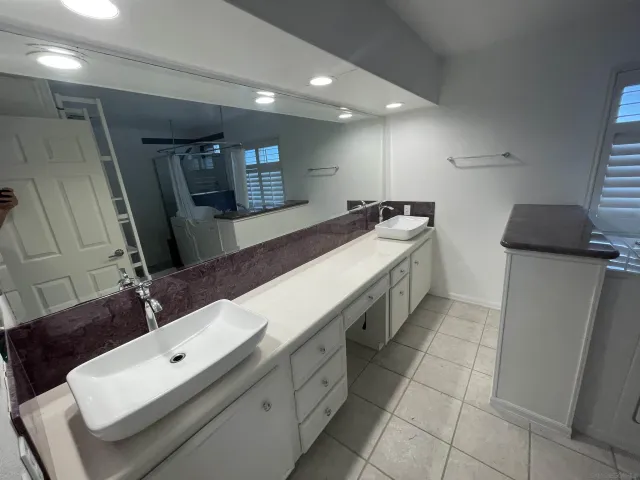 a bathroom with double vanity and a mirror