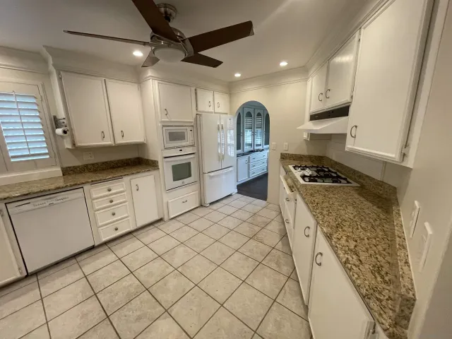 a kitchen with white cabinets and appliances