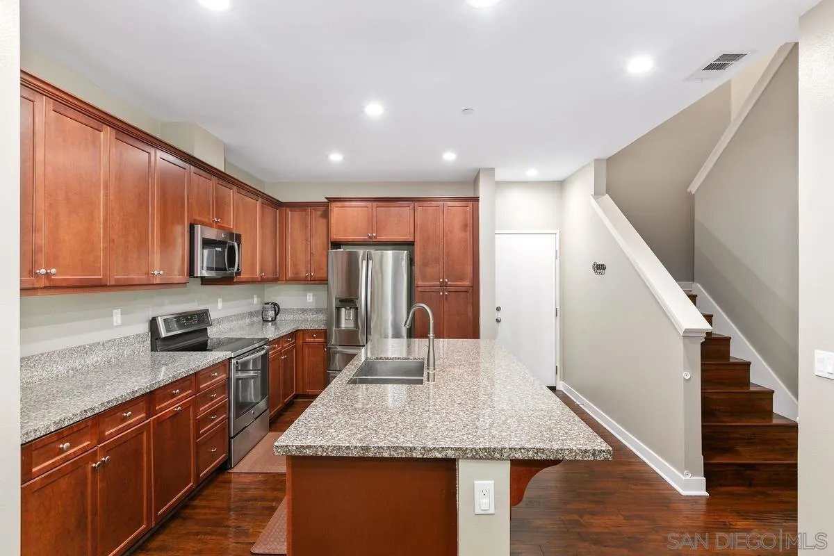 7508 Eagle Drive Santee, CA 92071 - Photo 4 of 22 a kitchen with stainless steel appliances granite countertop a refrigerator a stove top oven a sink and dishwasher