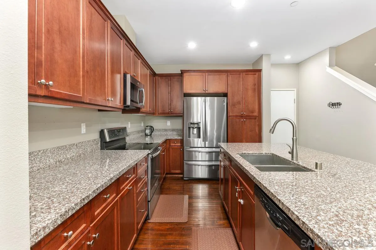7508 Eagle Drive Santee, CA 92071 - Photo 6 of 22 a kitchen with kitchen island granite countertop a sink refrigerator and cabinets
