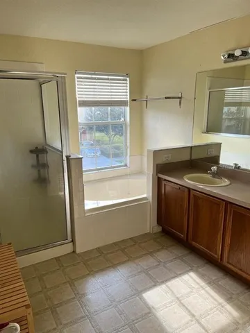 a bathroom with a granite countertop sink a mirror and a bathtub