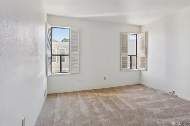an empty room with windows and closet