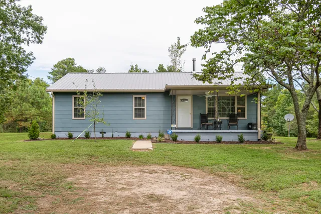 a front view of a house with a yard and trees