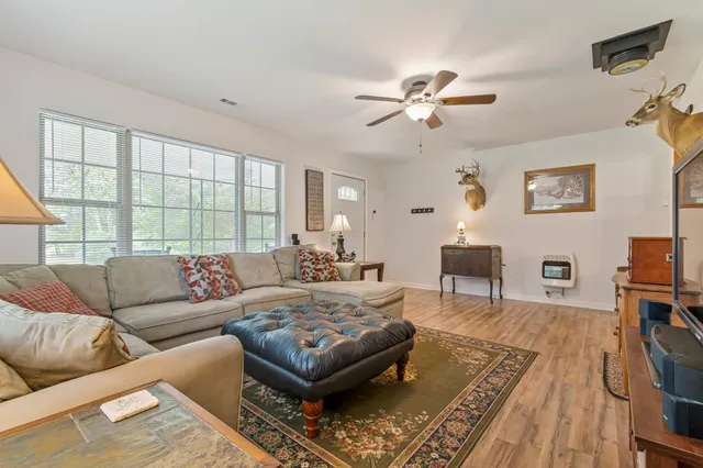 a kitchen with stainless steel appliances granite countertop a refrigerator a stove top oven a sink dishwasher and wooden cabinets with wooden floor