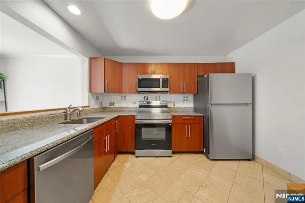 a kitchen with stainless steel appliances a refrigerator stove and microwave