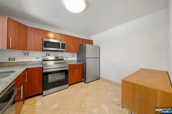 a kitchen with stainless steel appliances granite countertop a stove sink and cabinets