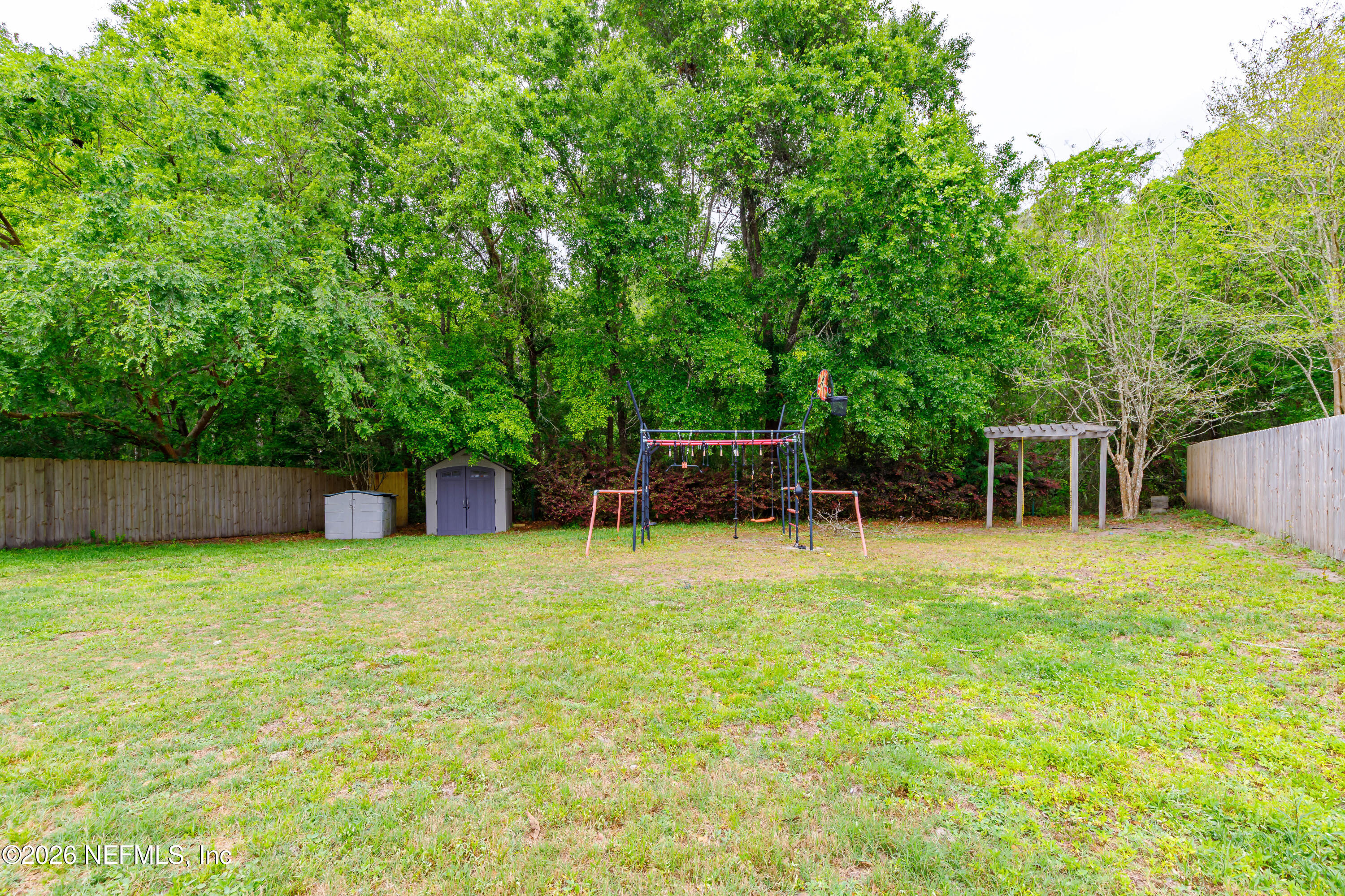 673 MacKenzie Circle St. Augustine, FL 32092 - Photo 27 of 28 a backyard of a house with plants and large trees