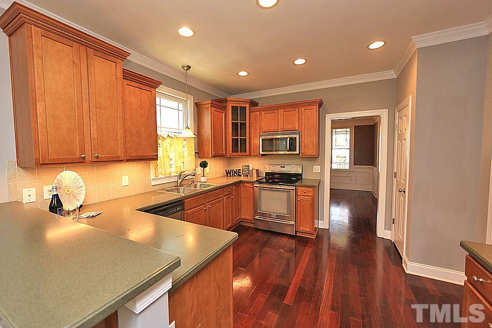 2108 Karns Place Raleigh, NC 27614 - Photo 9 of 26 a kitchen with wooden floors a sink and a stove