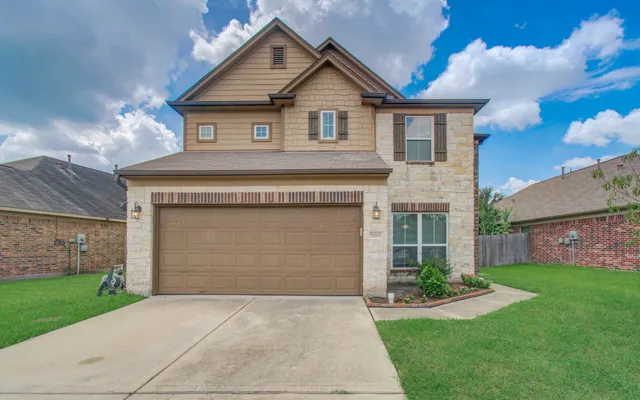 a front view of a house with a yard and garage