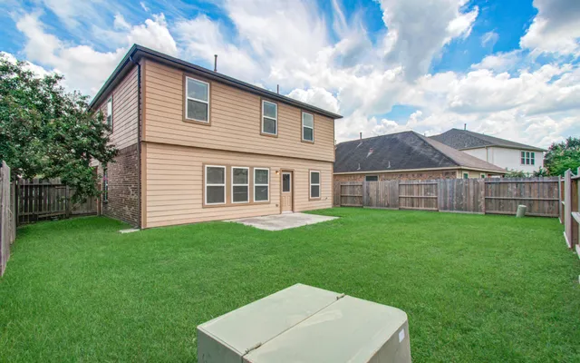 a view of a backyard with table and chairs and wooden fence