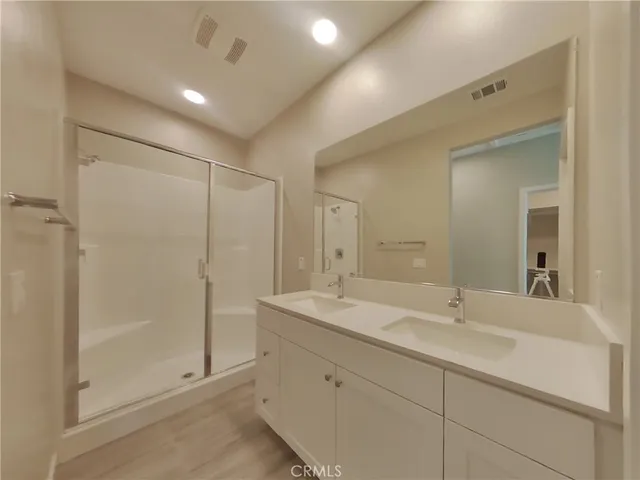 a bathroom with a shower sink and mirror