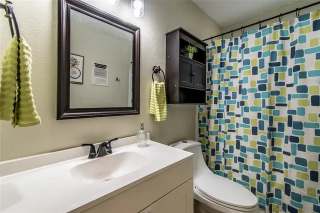 a bathroom with a sink toilet and shower