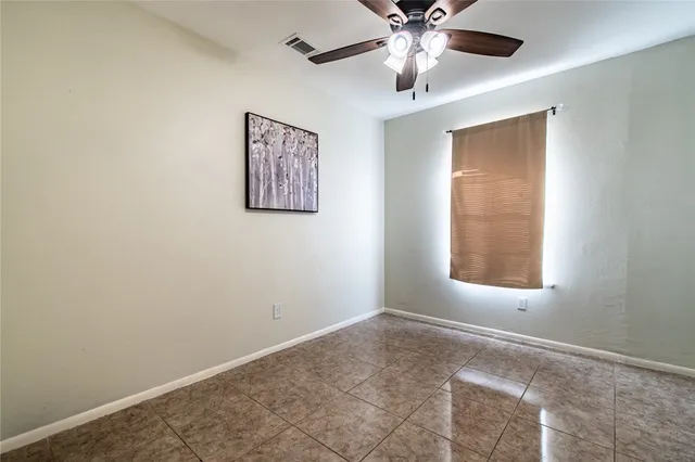 an empty room with windows and fan
