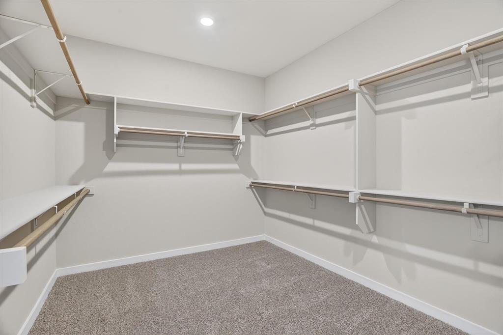 504 Clifton Court Springtown, TX 76082 - Photo 33 of 36 Spacious walk-in closet featuring white built-in shelving and multiple clothing rods