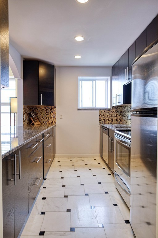 16 Addington Road, Unit 41 Brookline, MA 02445 - Photo 13 of 18 a kitchen with stainless steel appliances kitchen island granite countertop a stove a sink and a microwave
