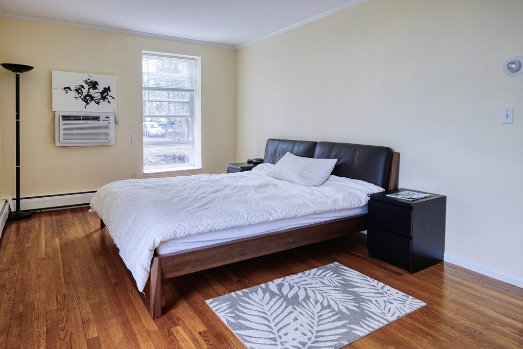 16 Addington Road, Unit 41 Brookline, MA 02445 - Photo 7 of 18 a bedroom with a bed and wooden floor