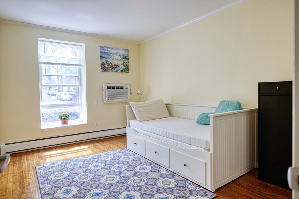 16 Addington Road, Unit 41 Brookline, MA 02445 - Photo 10 of 18 a bedroom with a bed and a window with wooden floor