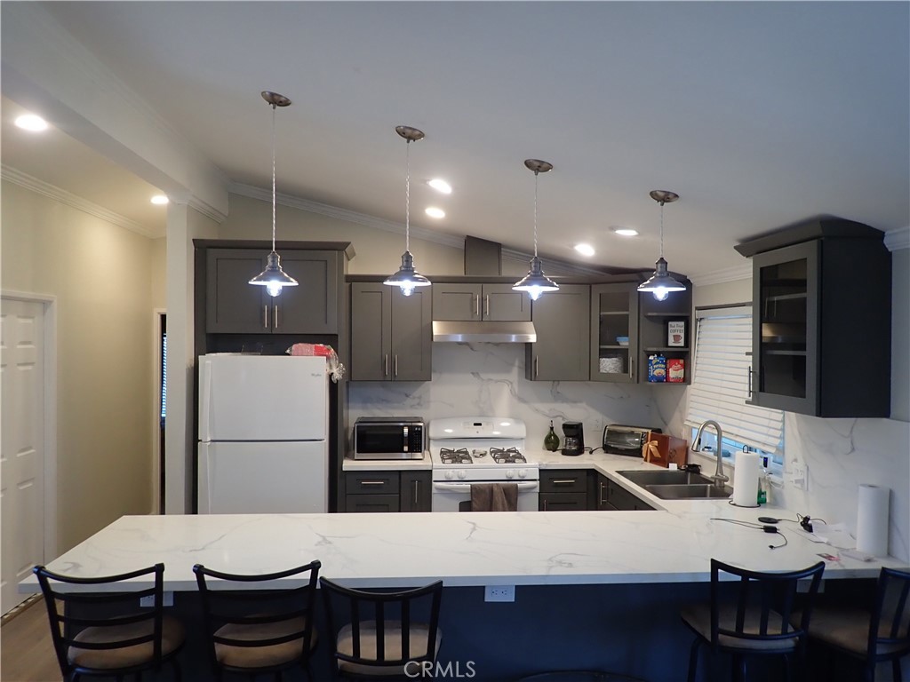 27250 Murrieta Road, Unit 386 Menifee, CA 92586 - Photo 8 of 32 a kitchen that has a refrigerator a stove a sink and a dining table with chairs